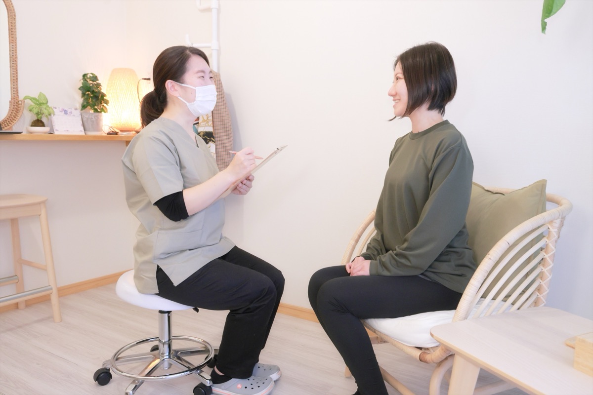 女性整体師がお客様と向かい合ってカウンセリングをしている様子